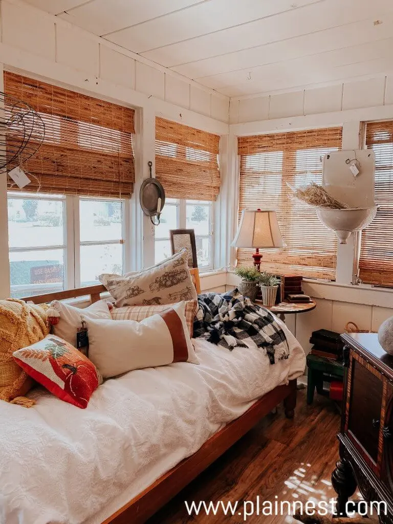 White bedding, curtains, furniture, walls, and ceiling fan